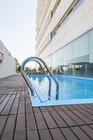 Una piscina al aire libre, sillones reclinables de piscina