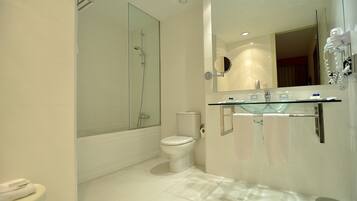 A modern bathroom with a glass-enclosed shower, a toilet, and a vanity with a mirror and towel rack.