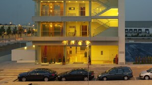A multi-story hotel with a modern design, featuring balconies, a staircase, and a ground-level entrance with a reception area. - Hotel Xon's Valencia (Quart de Poblet)
