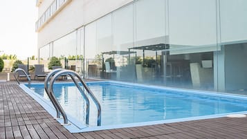 Alberca al aire libre y camastros