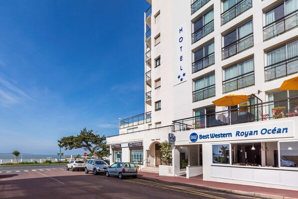 Un hôtel doté d’un balcon, une enseigne indiquant « Best Western Royan Ocean », et une vue sur l’océan.