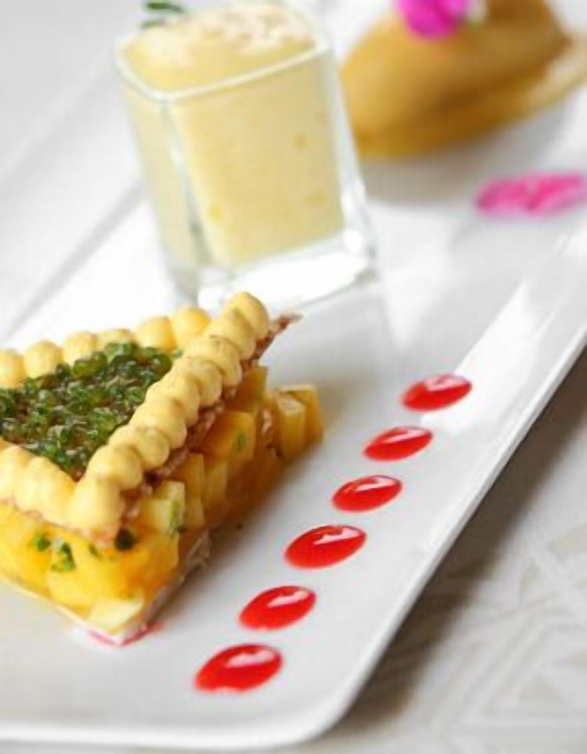 Un plato con una tarta, un vaso de una bebida cremosa y un pequeño pastel.