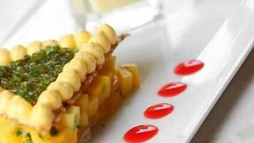 Un plato con una tarta, un vaso de una bebida cremosa y un pequeño pastel.