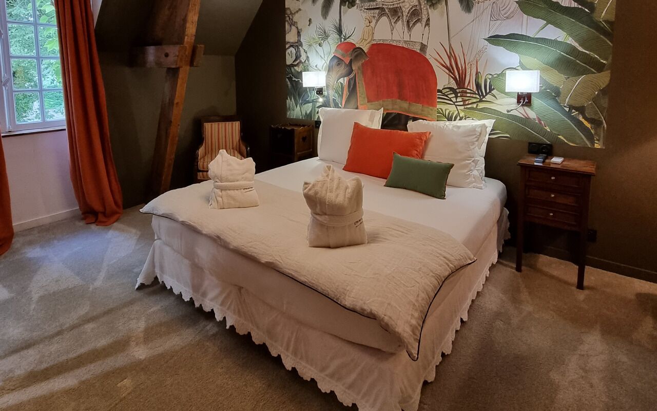 Un dormitorio con una cama grande, una mesita de noche, una lámpara y un mural en la pared.