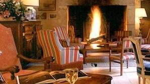 Uma sala de estar acolhedora com poltronas listradas, uma lareira e uma mesa de centro.