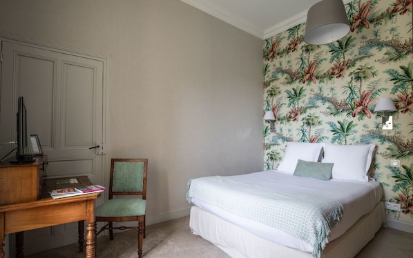 A bedroom with a bed, a desk with a chair, and a door. - Manoir d'Hautegente (Coly-Saint-Amand)