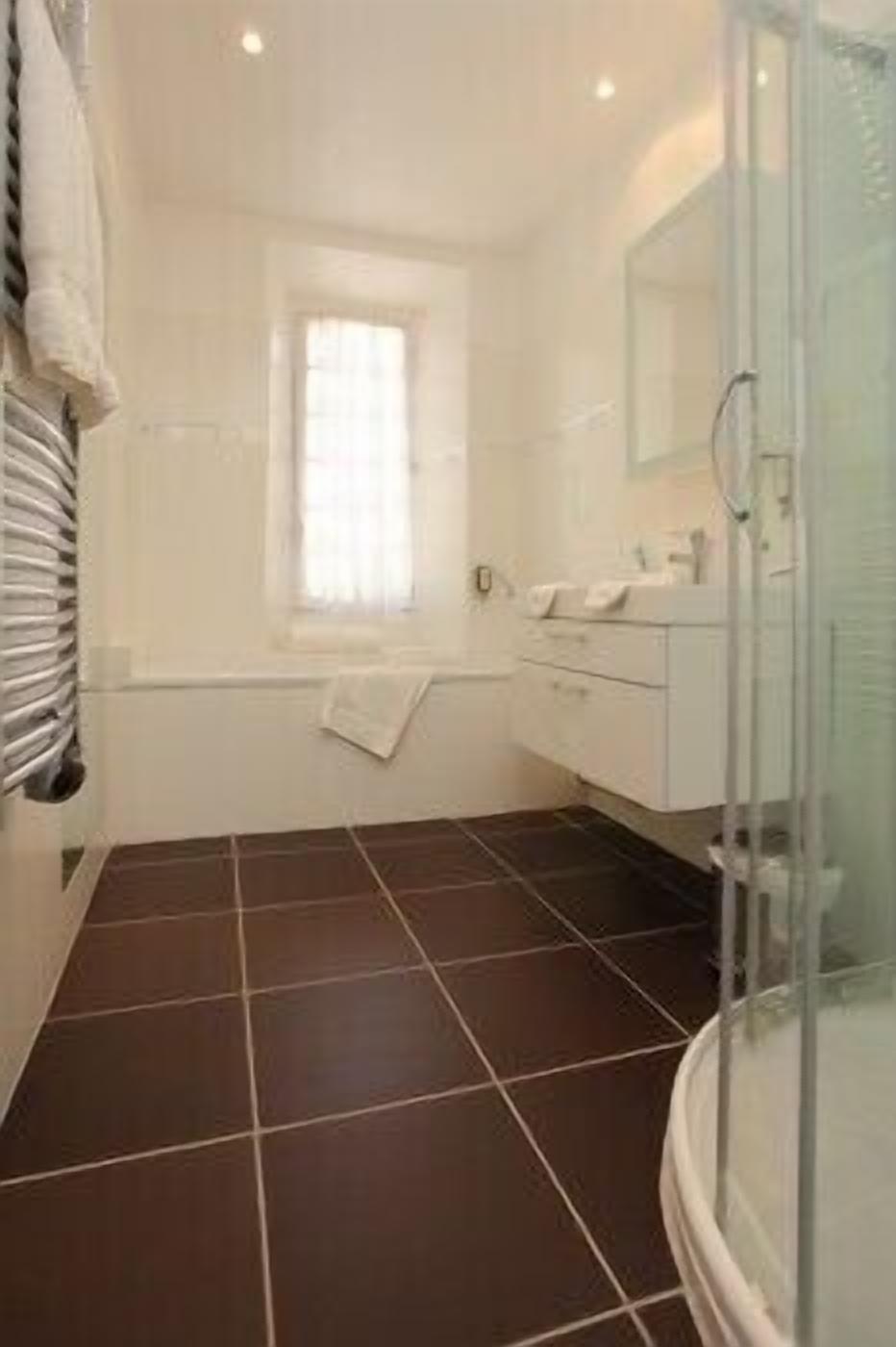 Un baño con bañera, ducha y ventana.