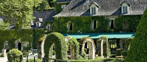 A historic building with ivy-covered walls and a traditional architectural style. - Manoir d'Hautegente (Coly-Saint-Amand)