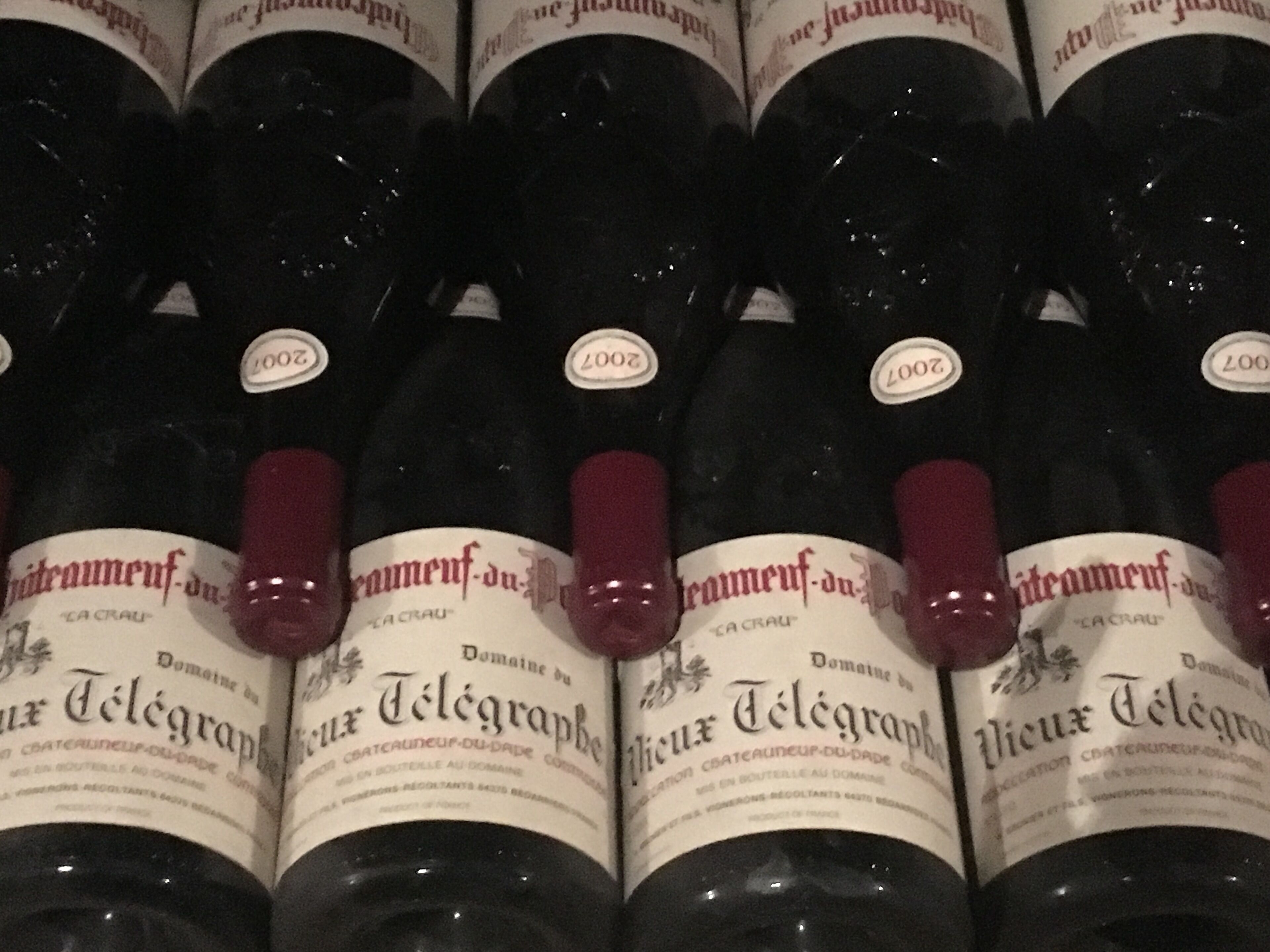 Multiple bottles of red wine with labels indicating 'Domaine du Télégraphe' and vintage years 2007 and 2008.