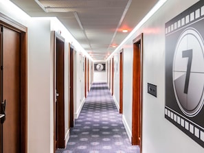 A hotel hallway with a carpeted floor, wooden doors, and a large number 7 sign on the wall. - ibis Styles Paris Mairie de Montreuil (Montreuil)