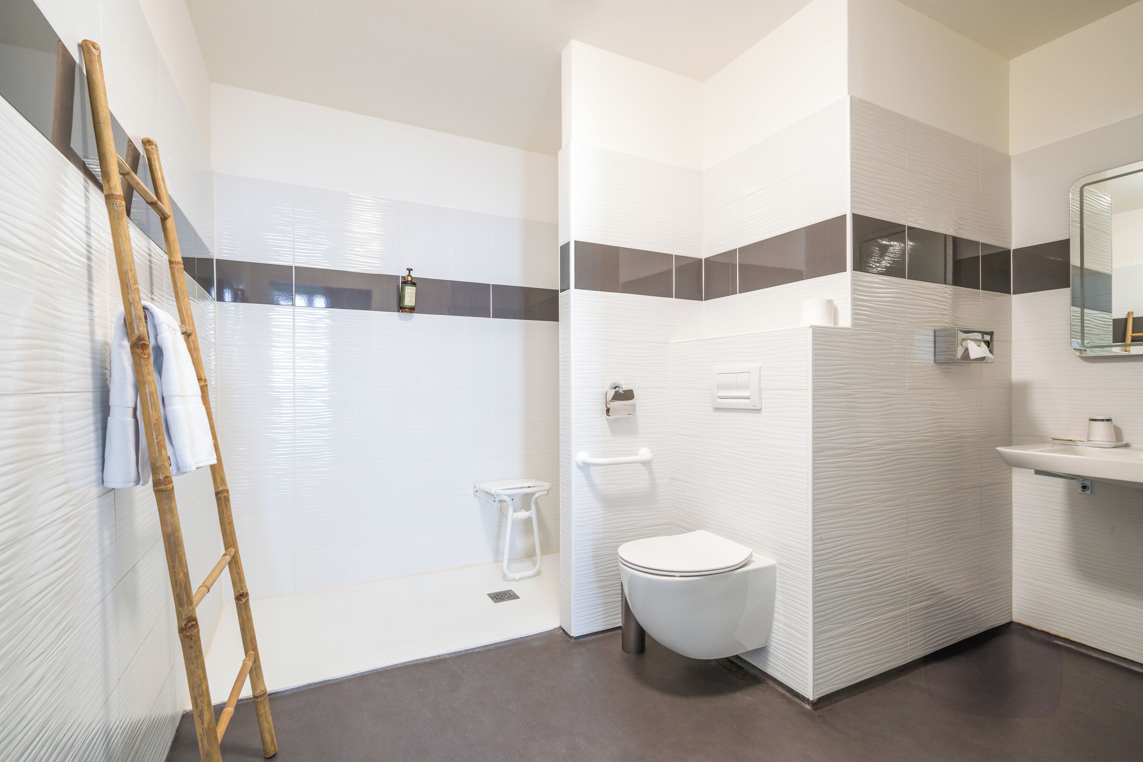 A modern bathroom with a shower, toilet, and sink.