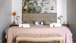 A bedroom with a large bed, two nightstands, a bench, and a wall-mounted lamp. - The Originals Boutique, Hôtel Le George, Loches (Loches)