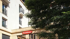 Un edificio con un letrero que dice Residhome y una entrada portonada.