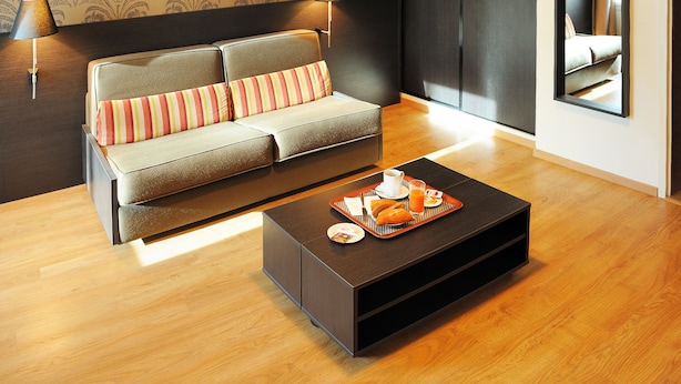 Una sala de estar moderna con un sofá, una mesa de centro y dos lámparas.