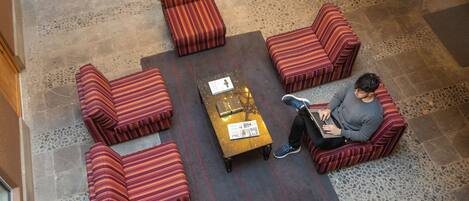 Un área de descanso con cuatro sillones a rayas y una mesa de centro con un posavasos.