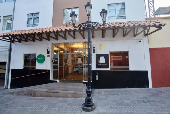 A building with a tiled roof entrance, a sign for 'Casa Andina', and a 'Sama' sign. - Casa Andina Standard Puno (Puno)
