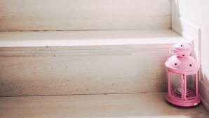 Una escalera adornada con faroles rosas colocados a intervalos.