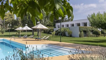 Una piscina al aire libre de temporada, sombrillas