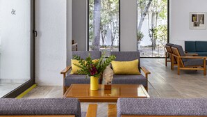 Uma sala de estar moderna com um sofá, uma mesa de centro e um vaso com flores.
