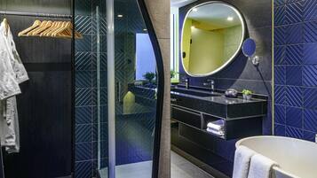 Un baño moderno con cabina de ducha de vidrio, tocador con espejo y bañera.