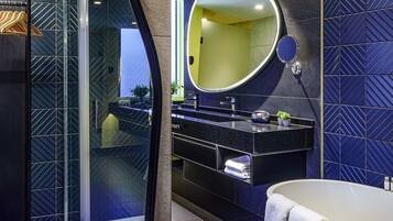 Un baño moderno con cabina de ducha de vidrio, tocador con un espejo grande y bañera.