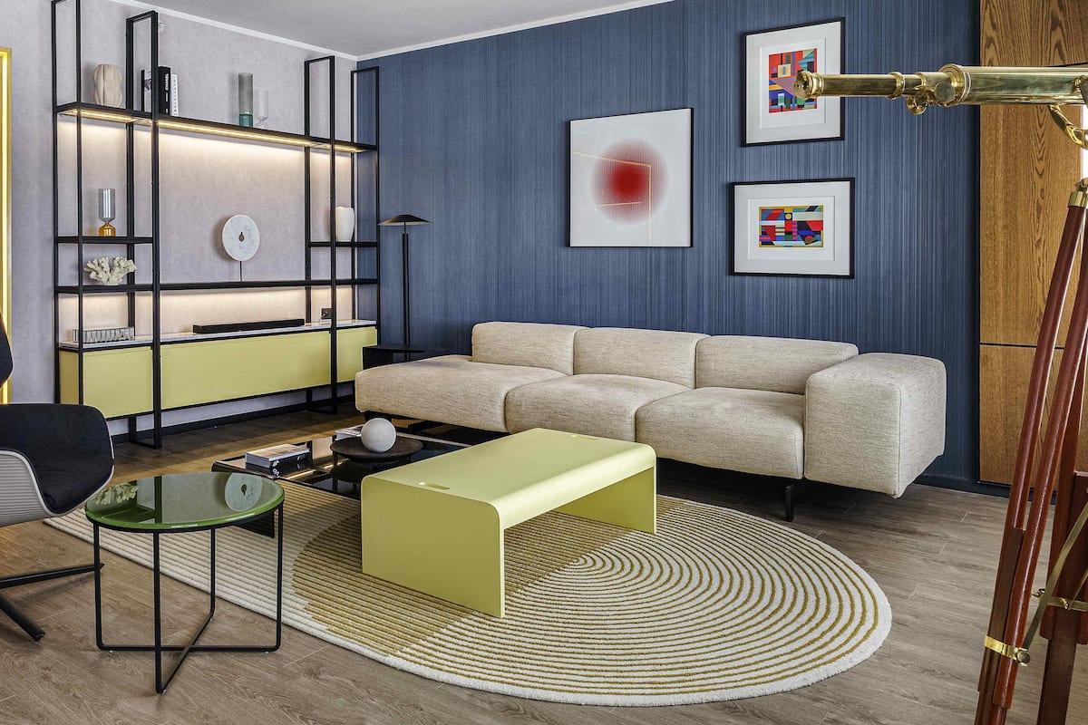 Ein modernes Wohnzimmer mit einer Couch, einem Couchtisch, einem Glastisch und einem Bücherregal.