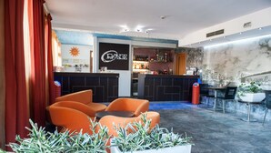 A modern bar area with a counter, seating, and a mural.