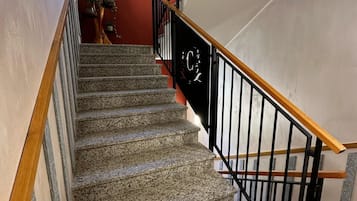 A staircase with granite steps, black railings, and a wooden handrail.
