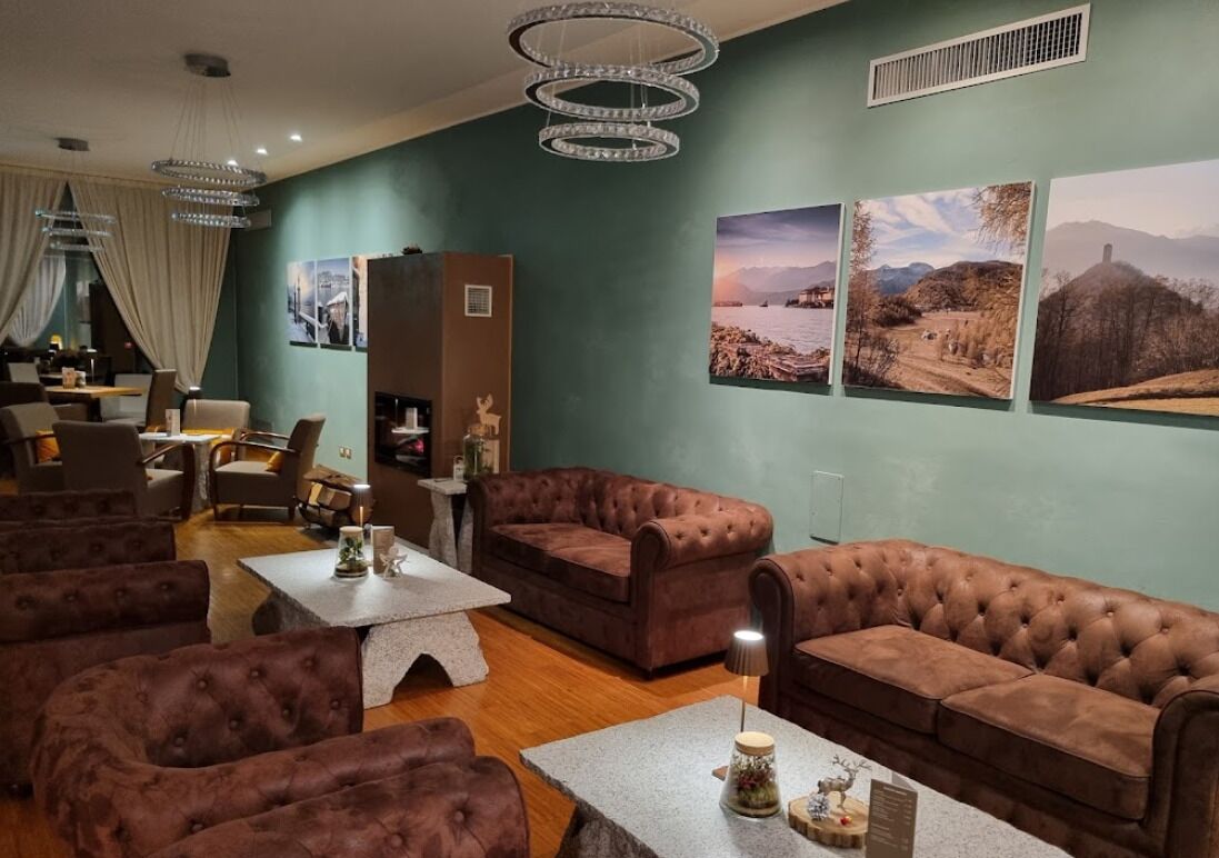 Una sala de estar moderna con sofás de cuero, una mesa de centro y una araña.