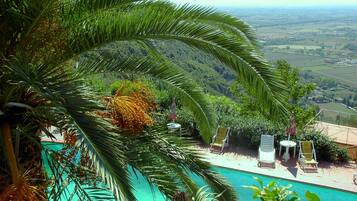 Alberca al aire libre y camastros