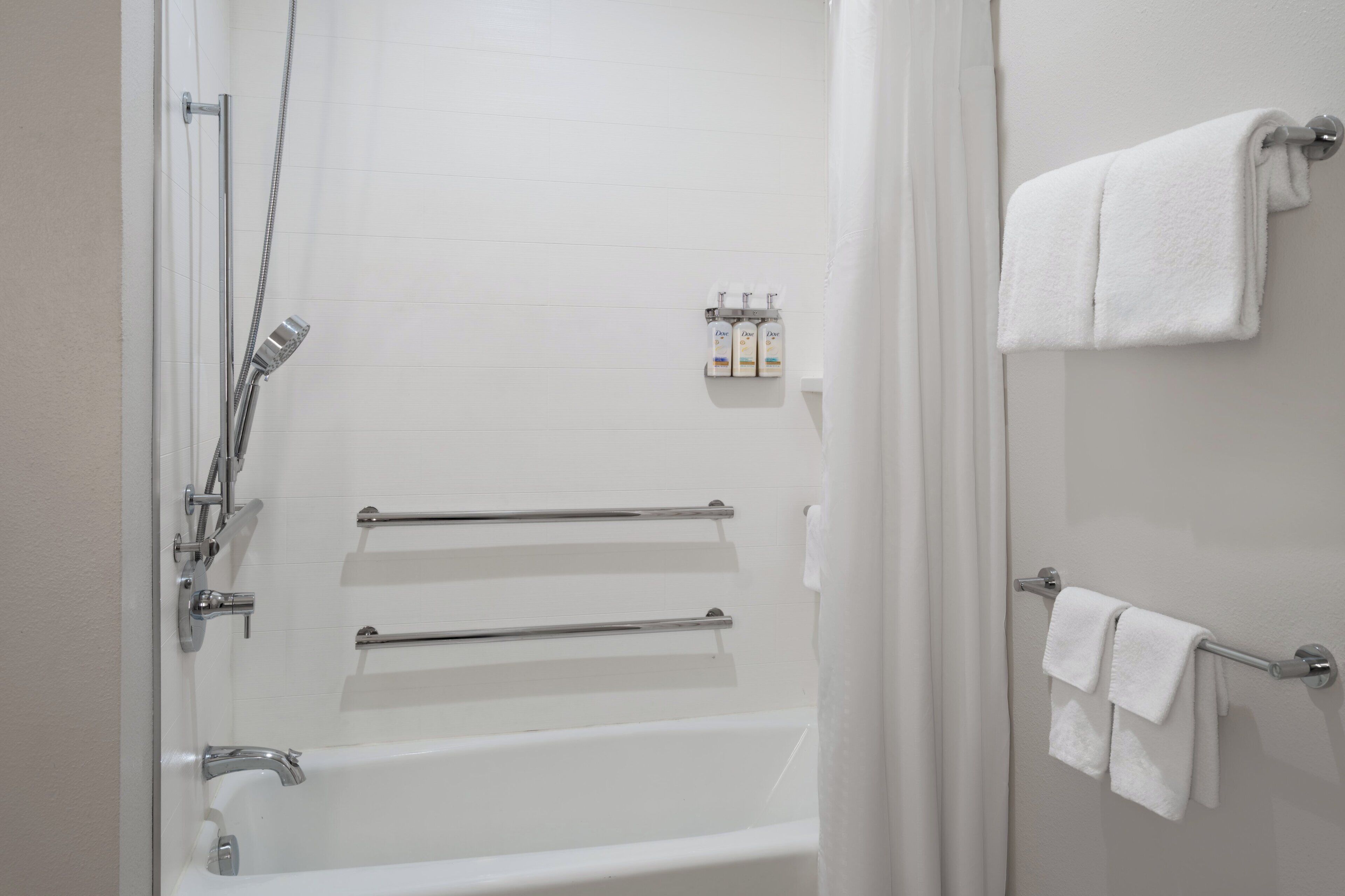 A bathroom with a bathtub, a shower, and a towel rack.