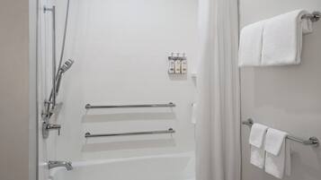 A bathroom with a bathtub, a shower, and a towel rack.