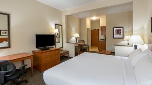 Ein Hotelzimmer mit Bett, Schreibtisch, Stuhl, Fernseher und einem durch eine offene Tür einsehbaren Badezimmer.