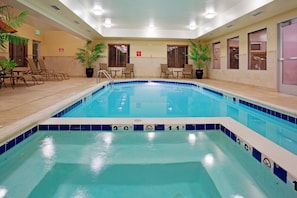 Una piscina techada, sillones reclinables de piscina