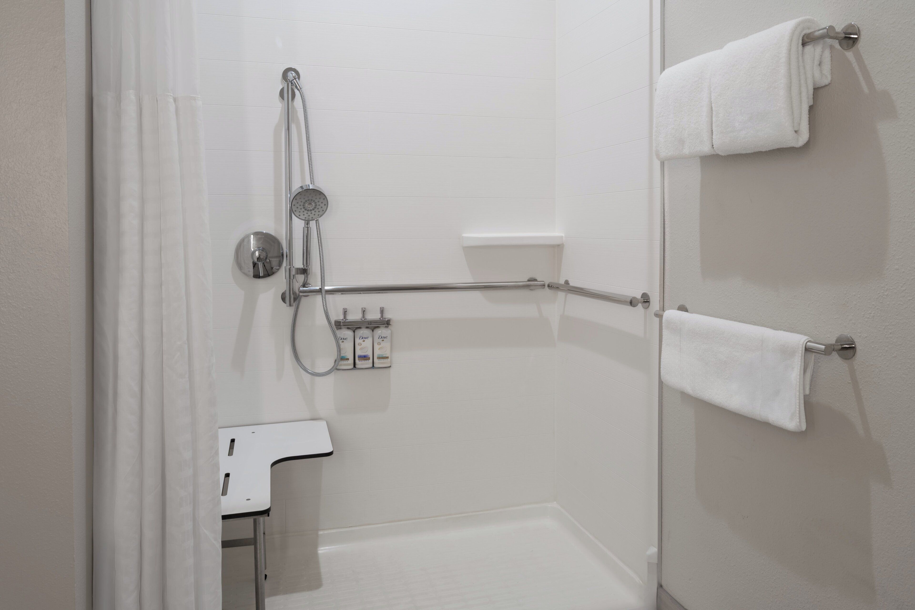 A bathroom with a shower, a toilet, and a towel rack.