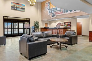 A lobby with leather sofas, a coffee table, a reception desk, and a wall with a map of the USA. - Big Horn Resort, an Ascend Collection Hotel (Billings)