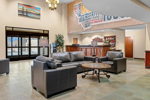 A lobby with leather sofas, a coffee table, a reception desk, and a wall with a map of the USA. - Big Horn Resort, an Ascend Collection Hotel (Billings)