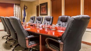 A conference room with a long table, six black leather chairs, and a flag on the wall. - Big Horn Resort, an Ascend Collection Hotel (Billings)