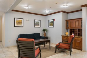 A living room with a sofa, two chairs, a coffee table, and framed pictures on the wall. - Suburban Studios Waterloo (Waterloo)