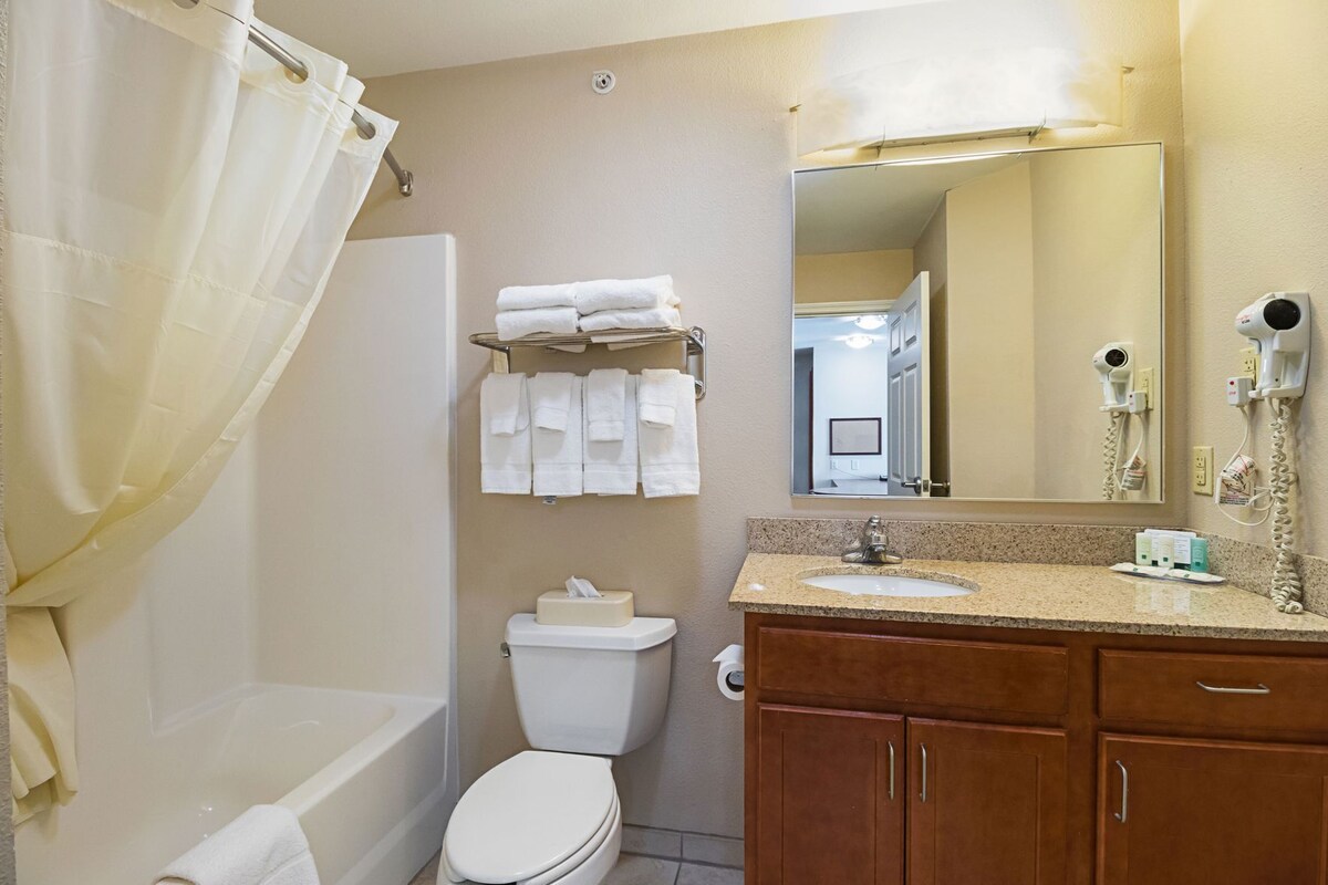 A bathroom with a bathtub, toilet, sink, and a mirror.