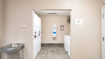 A laundry room with a sign indicating machines operate by credit card only.