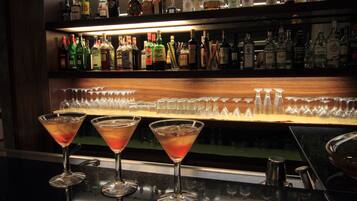 Zona bar con diverse bottiglie di liquori e bicchieri.