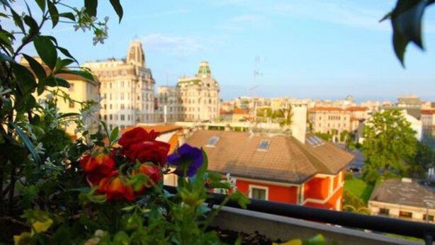 A cityscape with historic buildings and a red house in the foreground. - Hotel Metro (Milan)