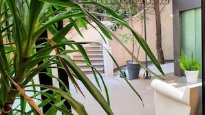 A modern interior with a glass door leading to an outdoor patio area. - Hotel Metro (Milan)