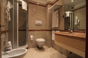 Un bagno moderno con doccia vetro, WC sospeso, lavandino e mobile con specchio.