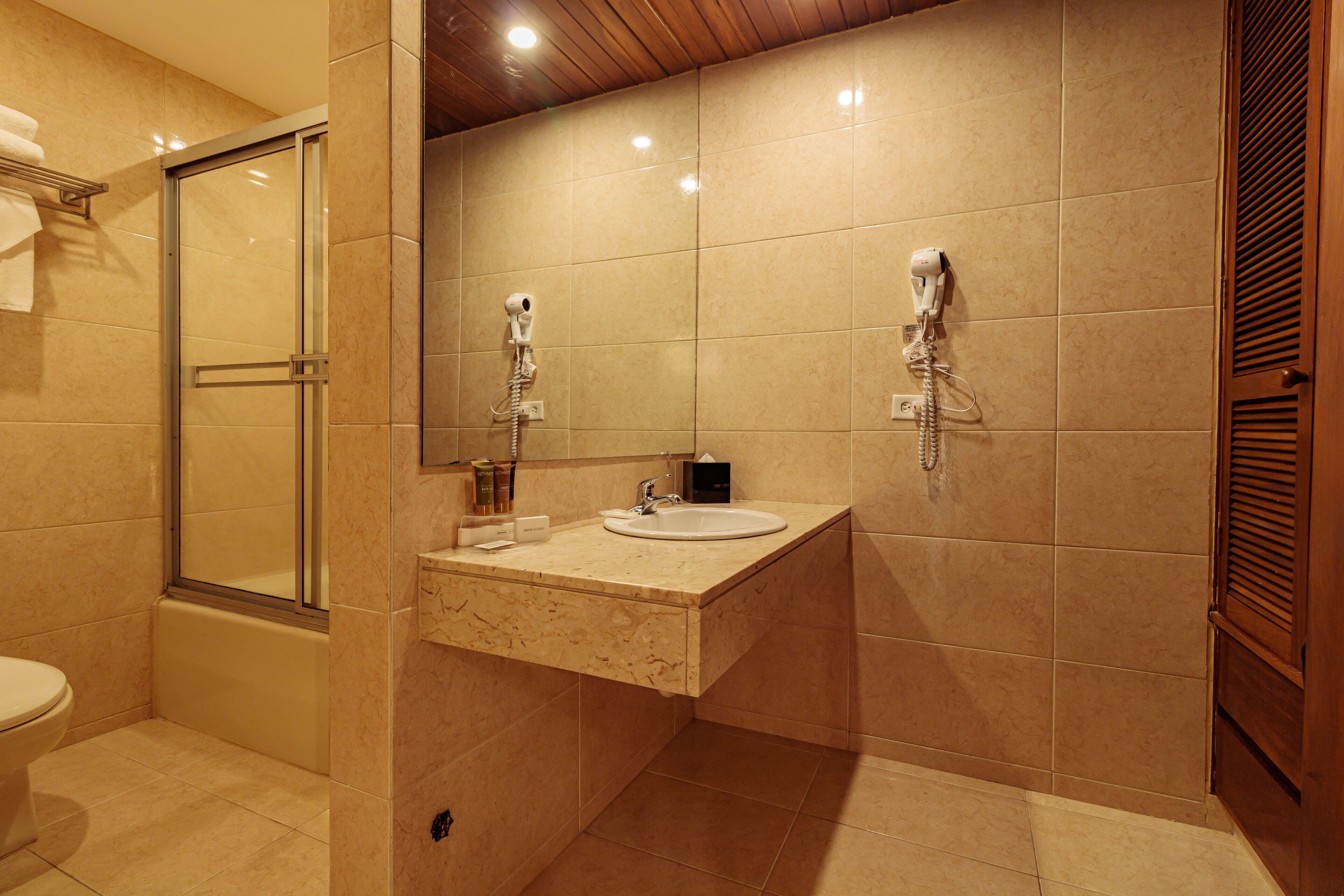 A modern bathroom with a glass-enclosed shower, a sink with a mirror, and a toilet.