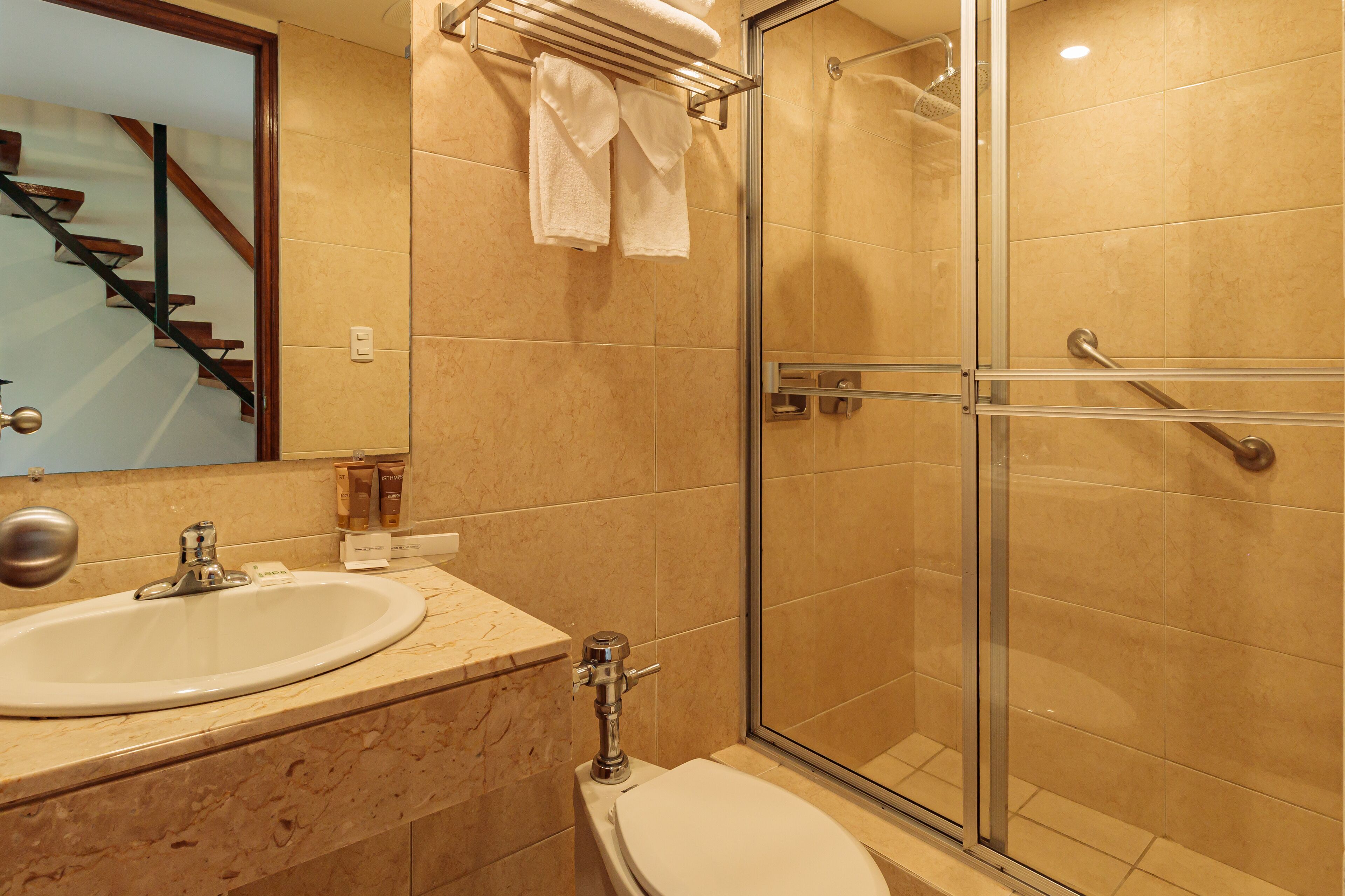 A bathroom with a sink, toilet, and glass-enclosed shower.