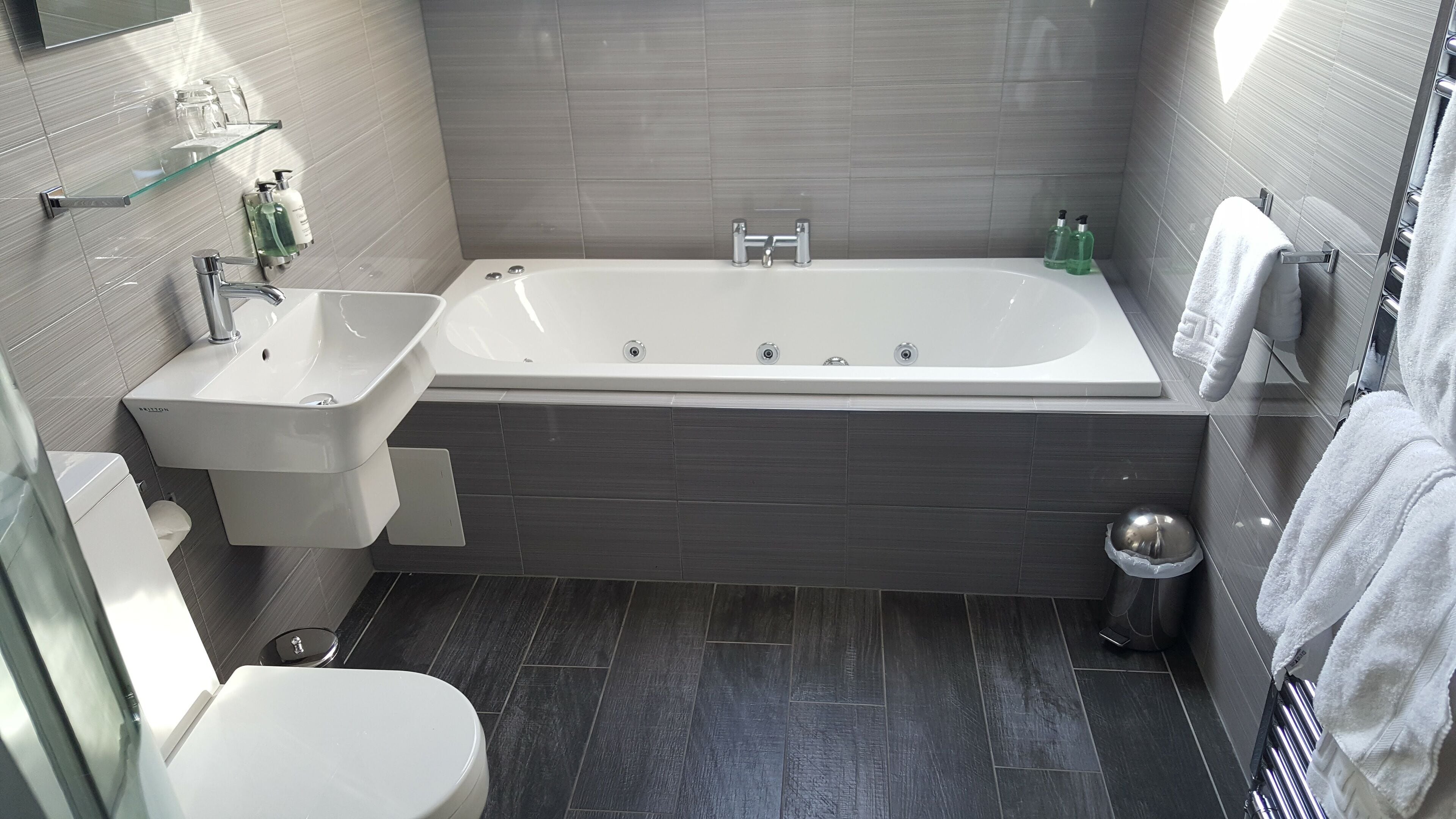 A modern bathroom with a bathtub, sink, and toilet.