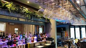 A bar area with a variety of liquor bottles, a bar counter, and hanging crystal chandeliers. - The Gailes Hotel and Spa (Irvine)