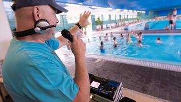 Una piscina techada, una piscina al aire libre de temporada, sombrillas